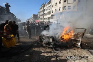 Warga Palestina berupaya memadamkan kendaraan yang terbakar setelah terkena serangan udara Israel di Kota Gaza pada 19 September 2026 [AFP]